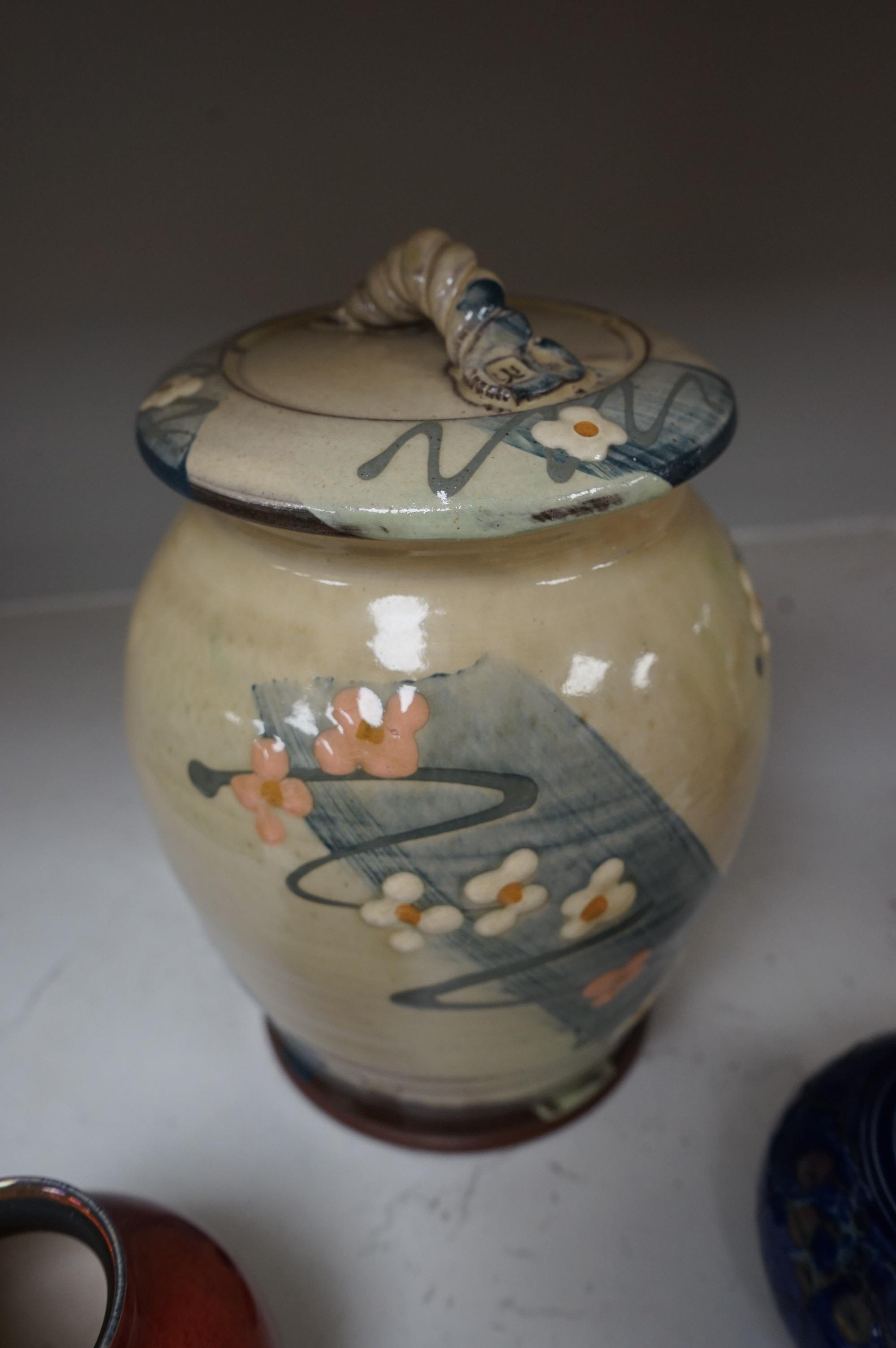 A Royal Lancastrian vase and a Dupuy vase and a Sally Shrimpton studio floral pottery jar and cover, largest 24cm high. Condition - good, Lancastrian vase chipped/cracked (3)